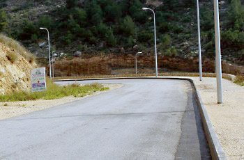 בתמונה שלפניך יש כמה גורמי דרך. מה צריכה להיות תגובת הנהג בהתקרבו למקום?